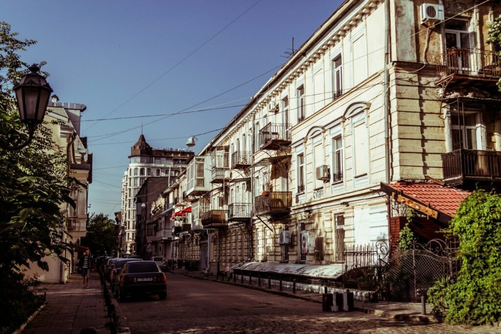 Old city street with ornate buildings and parked cars